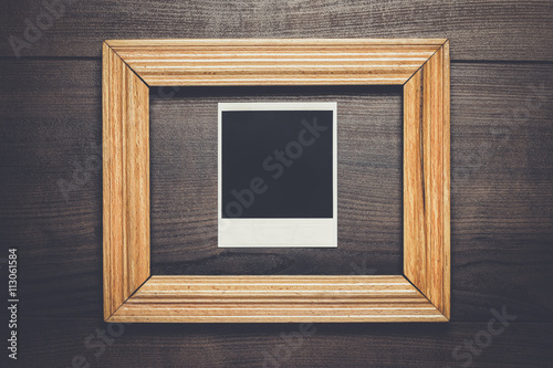 empty frame and old photo on the wooden background
