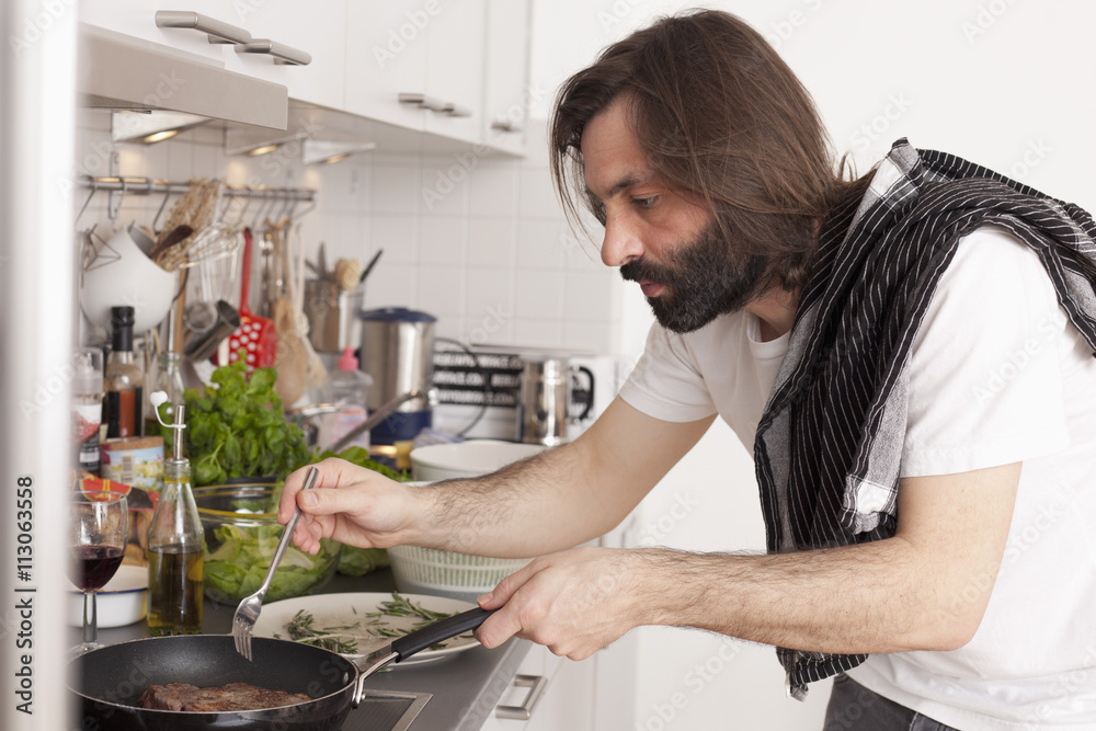 Mid adult man preparing meat in domestic kitchen Mid adult man preparing meat in domestic kitchen