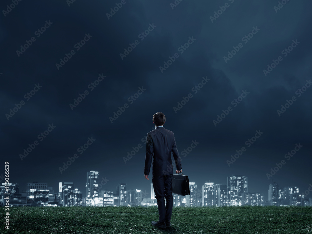 Businessman against night city view Businessman against night city view