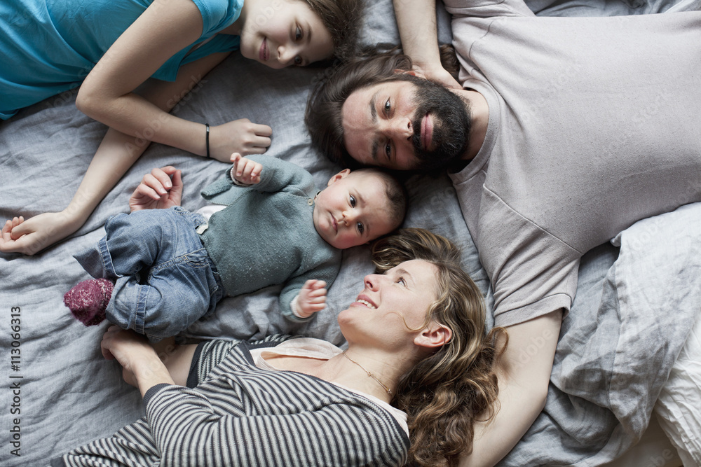 Overhead view of family relaxing on bed Overhead view of family relaxing on bed