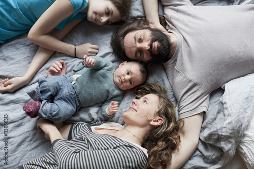 Overhead view of family relaxing on bed photo