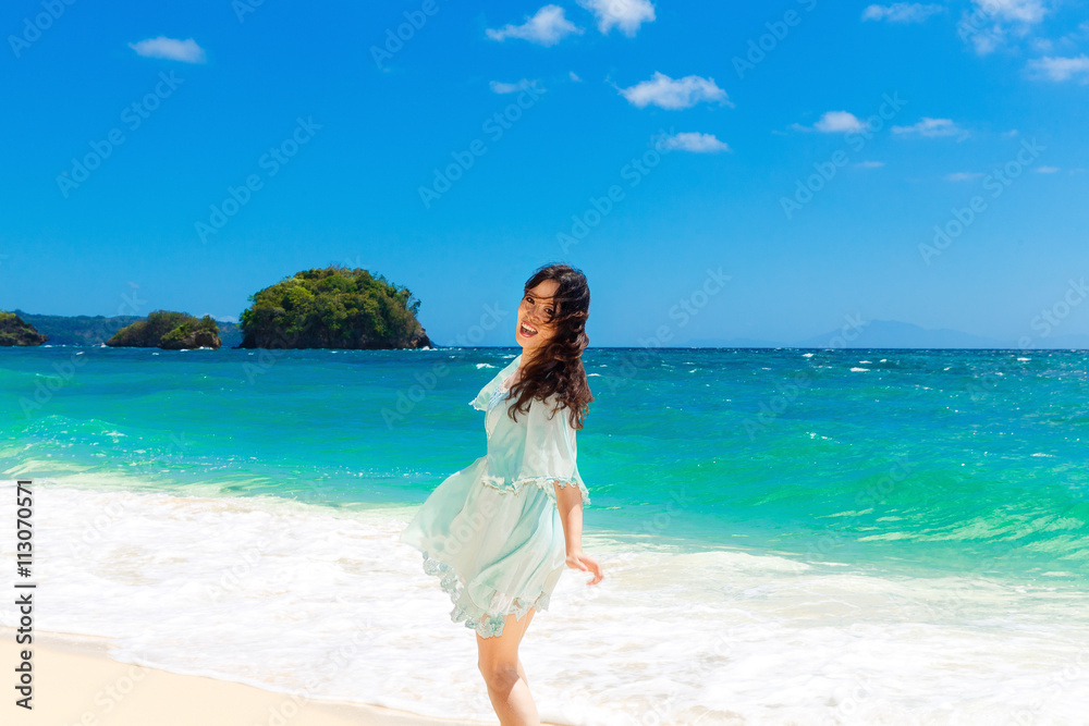 Young beautiful Asian  girl in blue dress on the beach of a trop