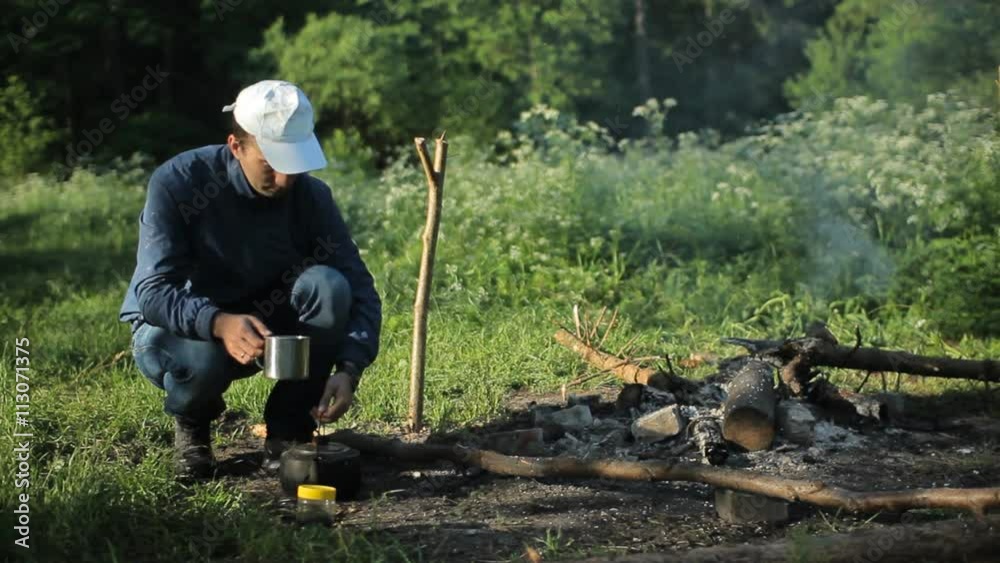 Man drink cup of tea nea campfire Man drink cup of tea nea campfire