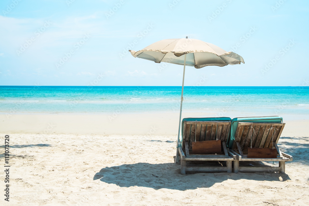 Beach bed with umbrella on white sand beach