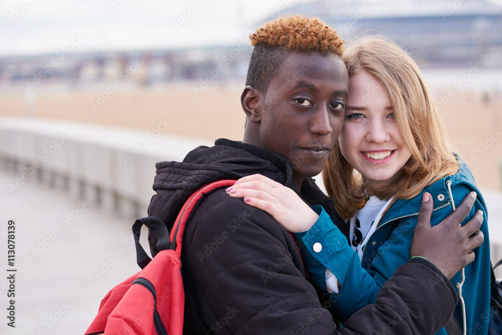 Portrait Of Loving Young International Couple on Sky Background. African Guy and Caucasian Woman