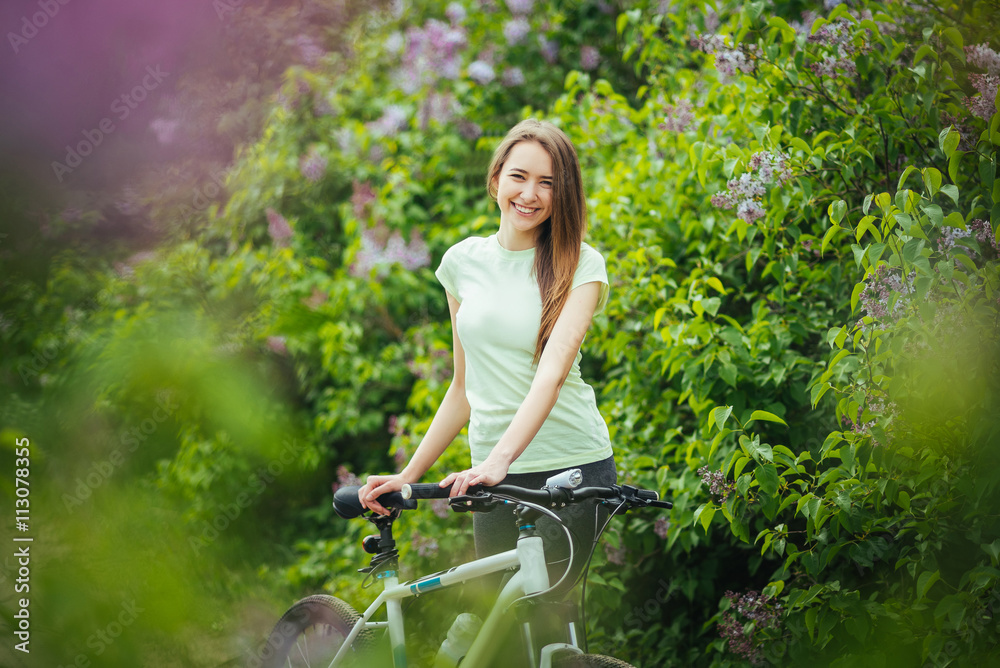 Happy young girl cyclist standing with a mountain bike and. Adventure travel. Happy young girl cyclist standing with a mountain bike and. Adventure travel.