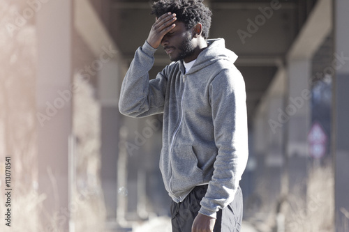 A man with his hand on his forehead with a look of dejection photo