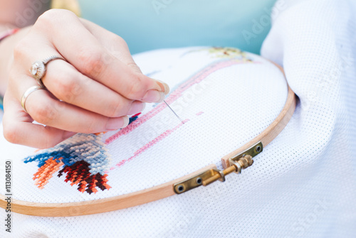 Female hand embroiders angels in the hoop.