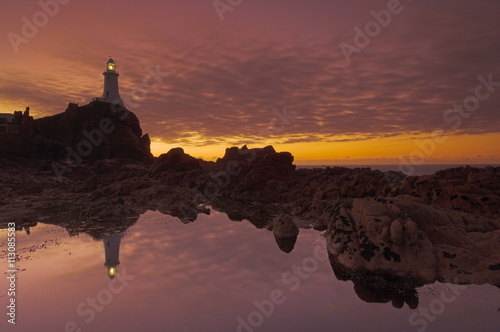 Dramatic sunset and low tide, Corbiere lighthouse, St. Ouens, Jersey, Channel Islands photo