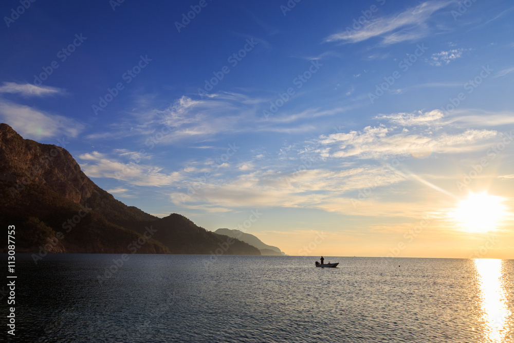 Fishing boat in the sea. Sunrise scene.