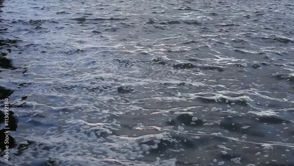 Surface water of a lake with calm, soft waves and froth Surface water of a lake with calm, soft waves and froth