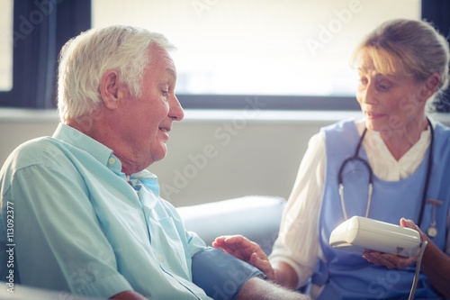 Female doctor checking blood pressure of senior man © WavebreakmediaMicro