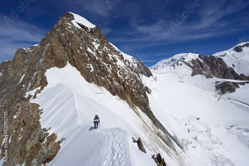 Climber on snow ridge, Aiguille de Bionnassay on the route to Mont Blanc, French Alps, France