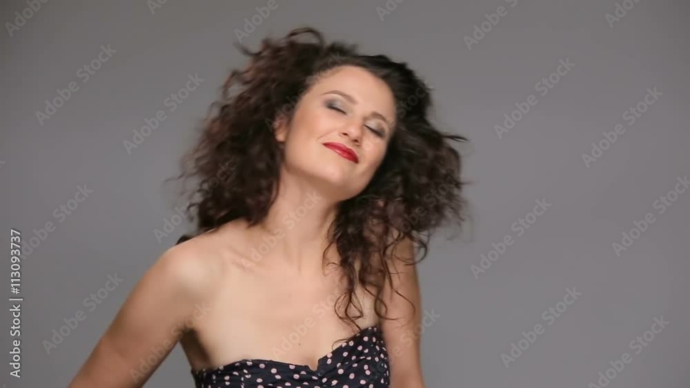 Young brunette with long brown curly hair dancing Young brunette with long brown curly hair dancing