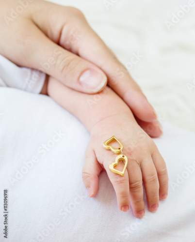 hand of the newborn child in caring hands