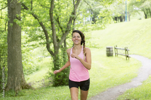 sporty woman running outdoors in park