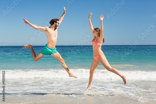 Couple jumping on beach