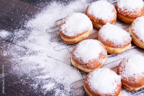 German donuts - berliner with icing sugar on a dark wooden background