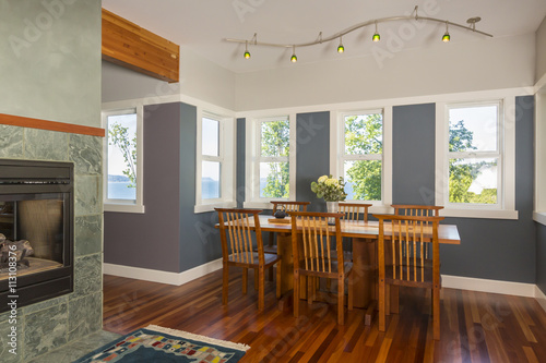 Vászonkép Dining area table and chairs with wood floors, painted walls, accent lighting an