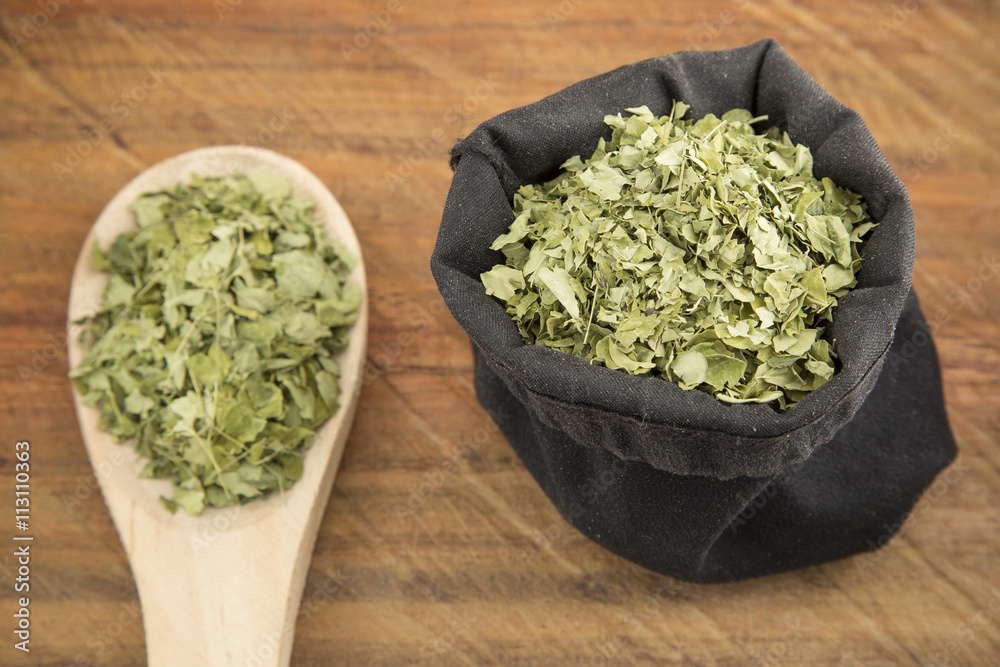 Moringa leaves on wooden background Moringa leaves on wooden background