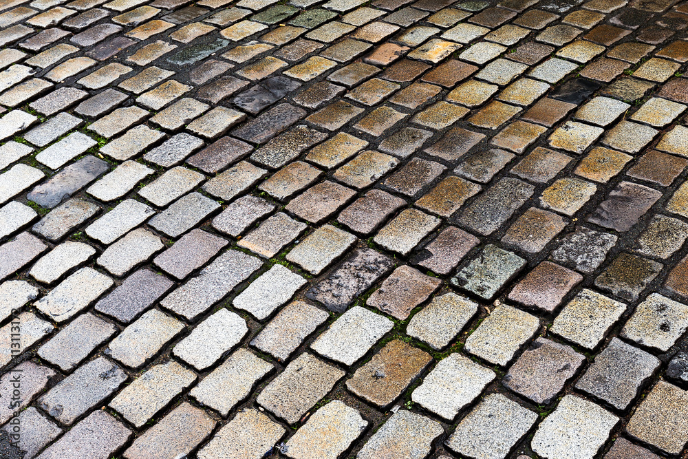 Wet cobblestone street, ideal for backgrounds and textures.