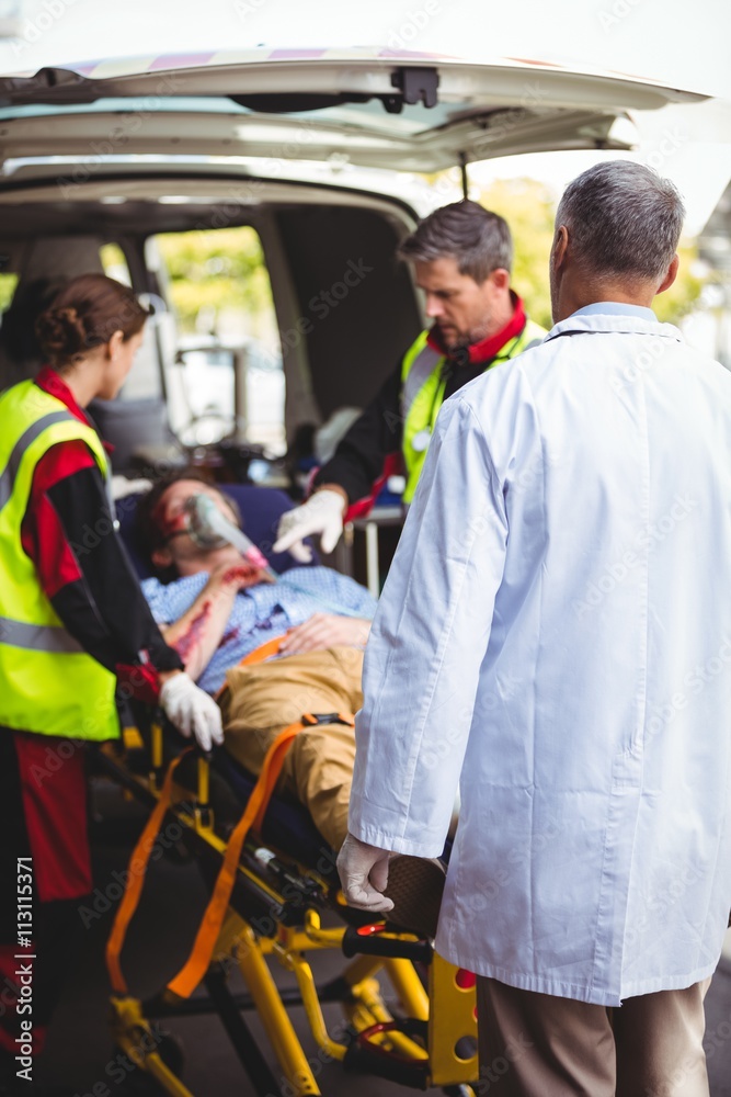 Ambulance crew and doctor taking care of an injured person Ambulance crew and doctor taking care of an injured person
