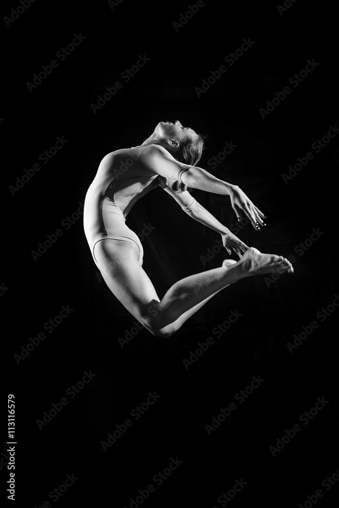 Silhouette image of beautiful girl in dancing jumping or flying on black copy space background