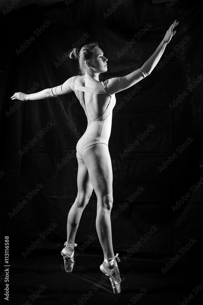 Image silhouette of beautiful young lady in dancing pose on black background