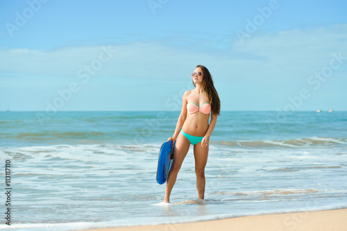 Pretty surfer young lady on the beach with bodyboarding, ready for fun