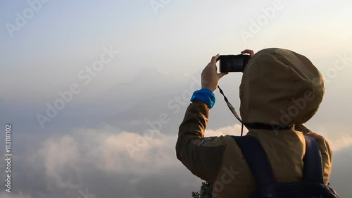 Asian woman watching the sunrise from the observatory of Poon Hill and taking photos of the beautiful panoramic view in Annapurna mountains in Nepal  photo