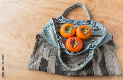 persimmon in  jeans patchwork  bag on table