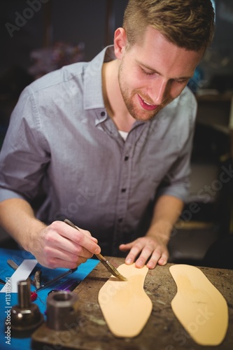 Cobbler applying glue on insole