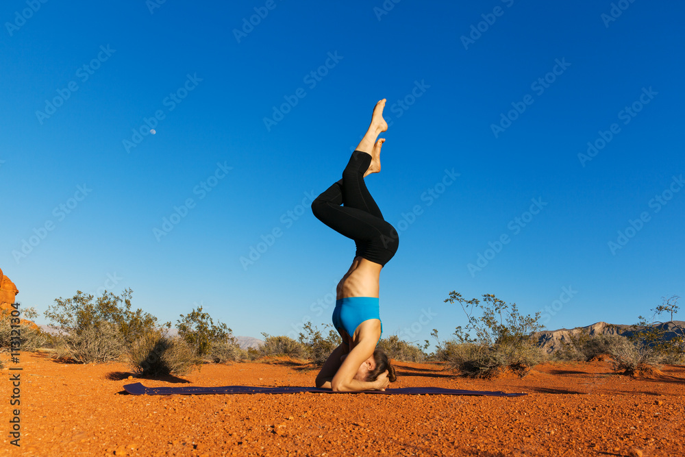 Young woman doing yoga in desert at sunset time