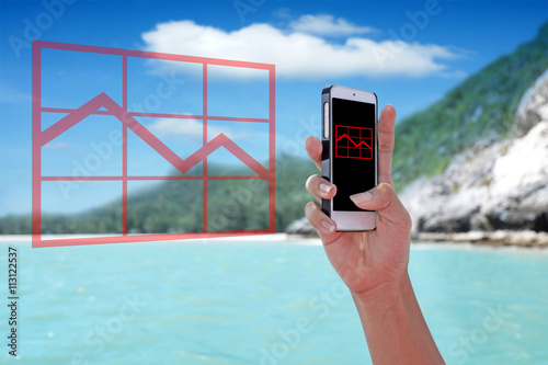 "Red falling graph chart" showing on the smartphone with tropical island background.