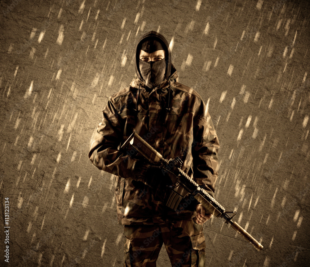 Dangerous heavily armed terrorist soldier with mask on grungy ra