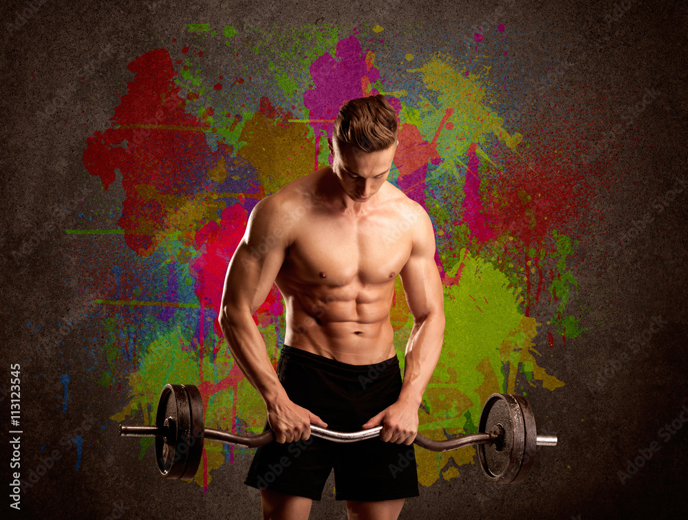 Strong guy with colorful paint wall and weight Strong guy with colorful paint wall and weight