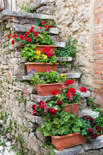 Colorful boxes of flowers on old stone stairs