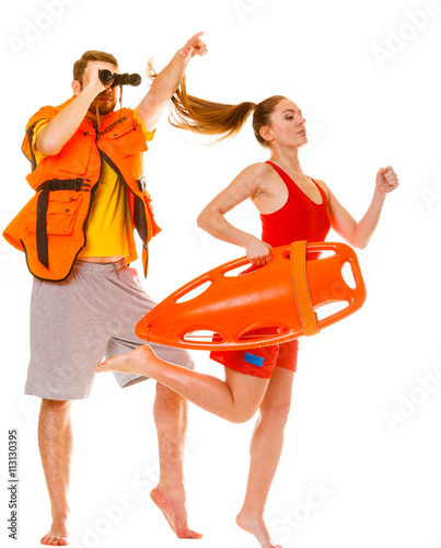 Lifeguards in life vest with rescue buoy running © Voyagerix