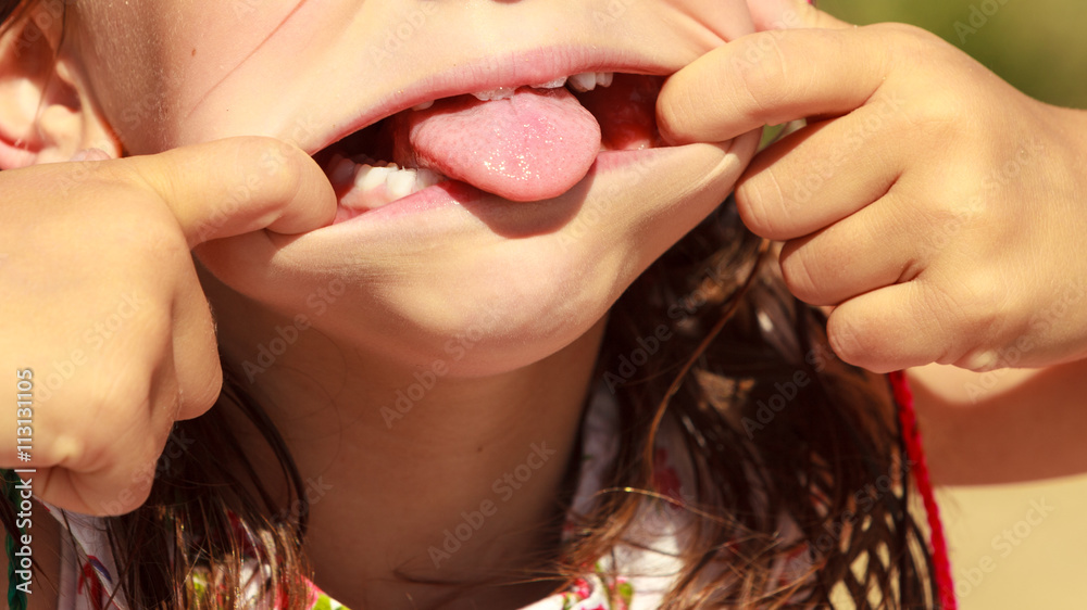 Φωτογραφία Closeup kid making silly face sticking out tongue