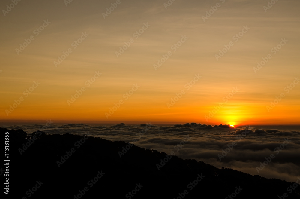 Sunrise over foggy valley mountains