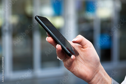Frau schreibt eine SMS mit ihrem Handy