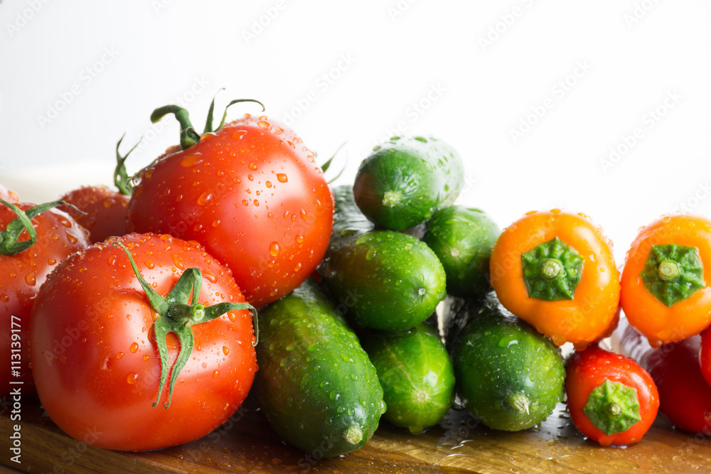Raw vegetables on kitchen cut board, composition on white backgr Raw vegetables on kitchen cut board, composition on white backgr