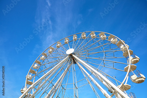 Ferris wheel against blue sky, copy space.