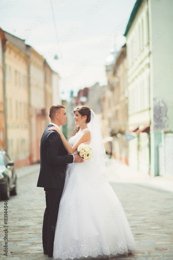 Naklejka premium Happy bride and groom dancing on a street