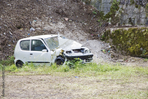 White decayed car in a scrap yard