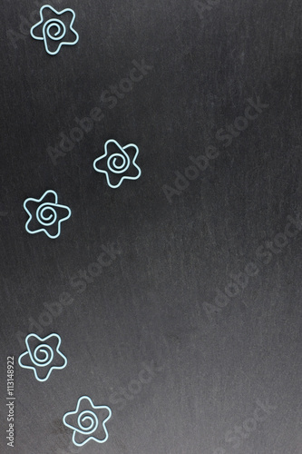 Group of funny paper clips on a dark stone background, a lot of