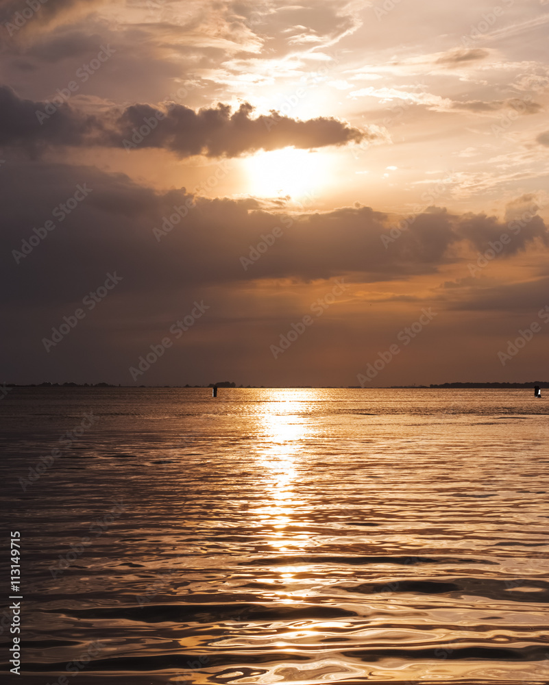 Fototapeta premium Blazing and vibrant orange summer sunset over Venice lagoon 