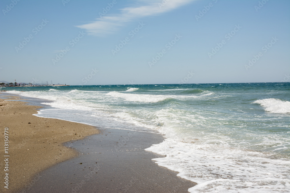 Waves, white sand beach and blue sky