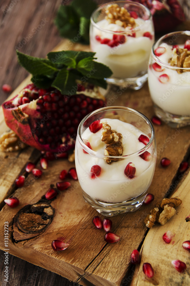 yogurt dessert with walnuts and pomegranate selective focus