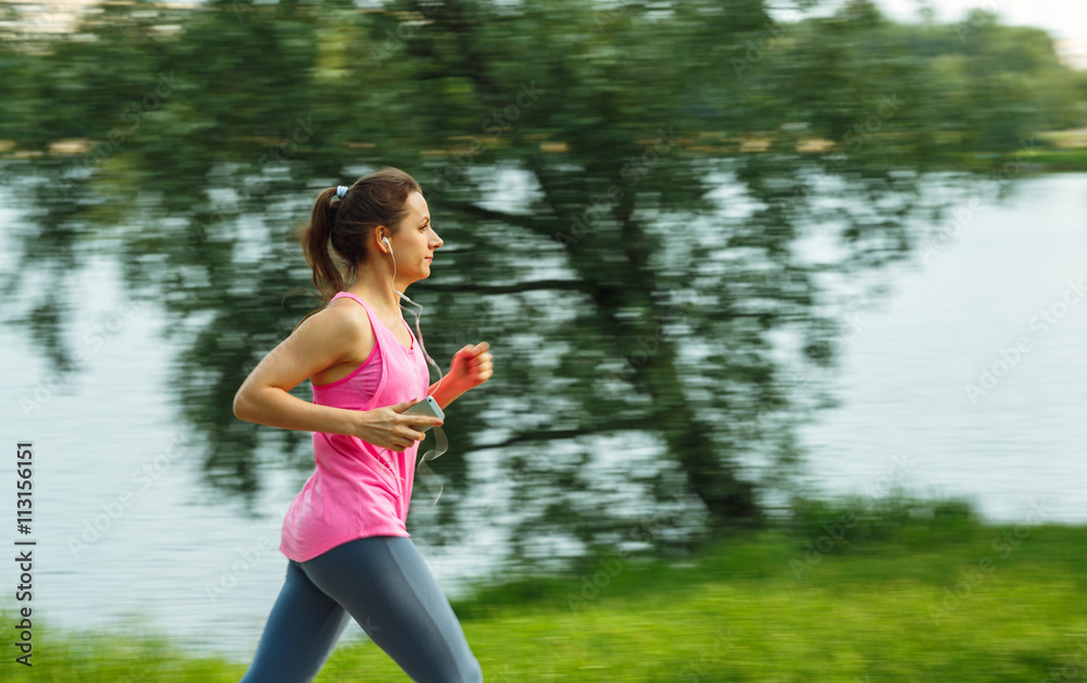 Young woman runner running on trail in the morning